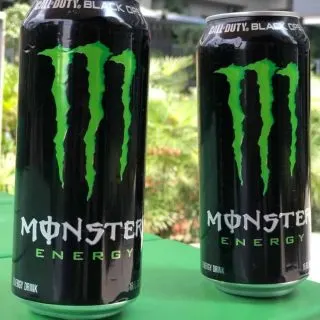 Two regular cans of Monster Energy Drink.