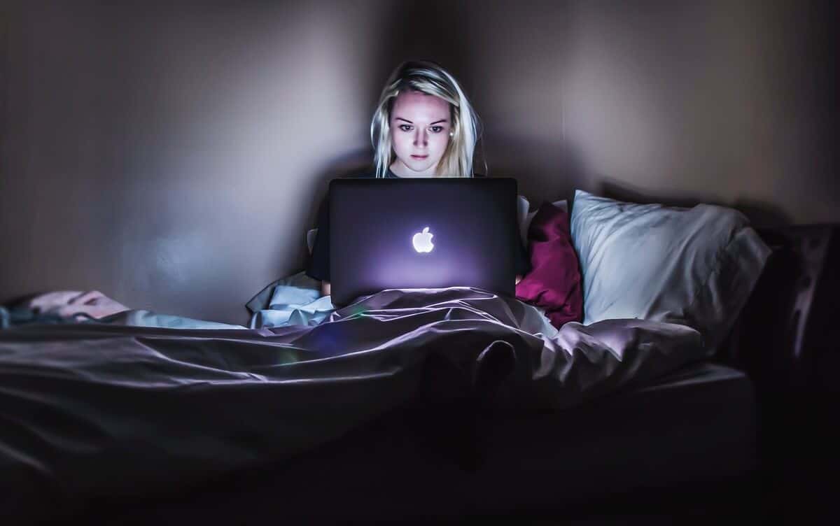 Girl in bed with laptop at night