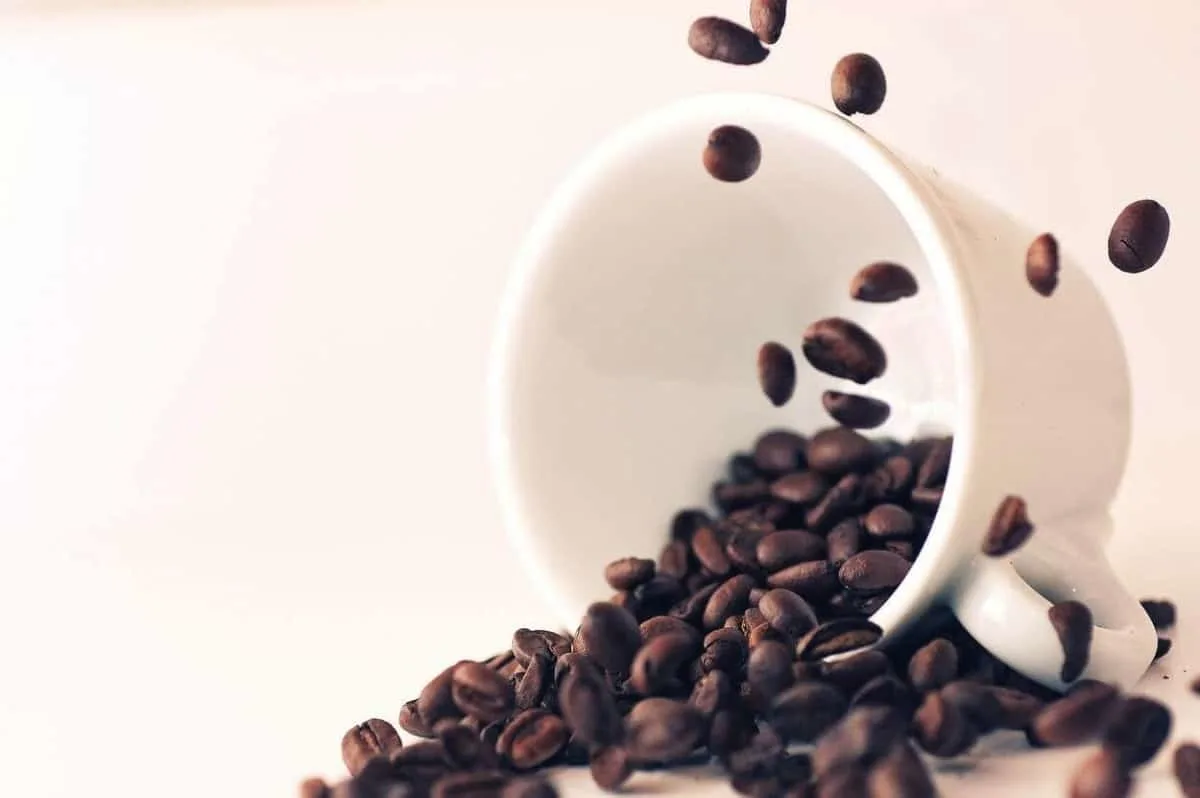A photo of coffee beans in a mug.