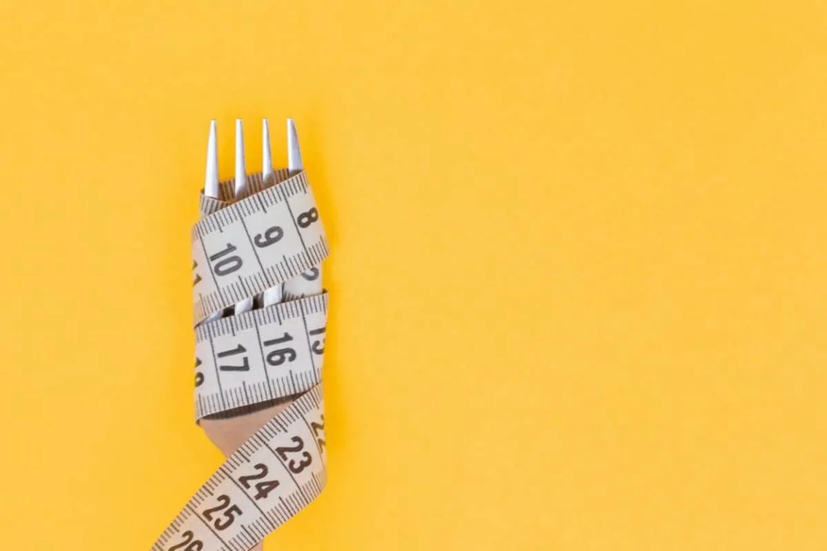 An image of a fork wrapped in measuring tape.