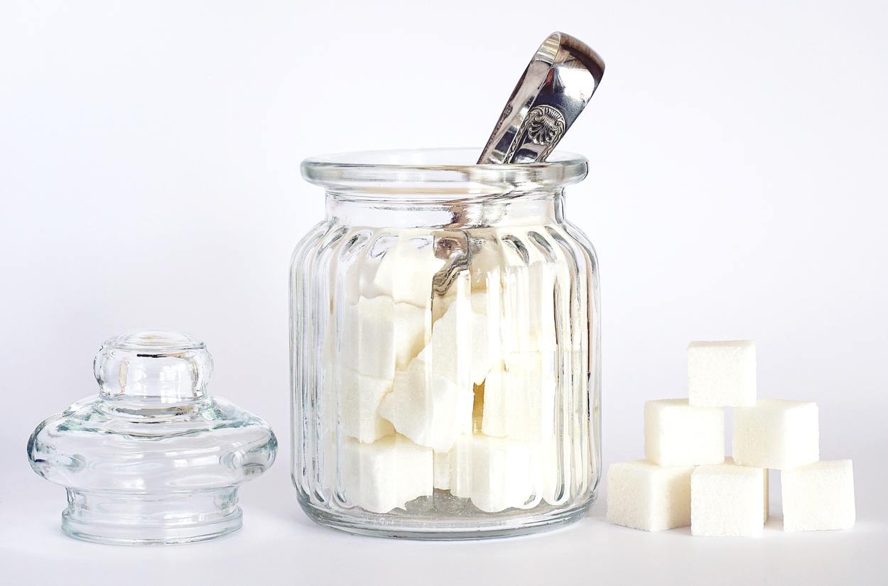 An image of pot of sugar containing sugar cubes