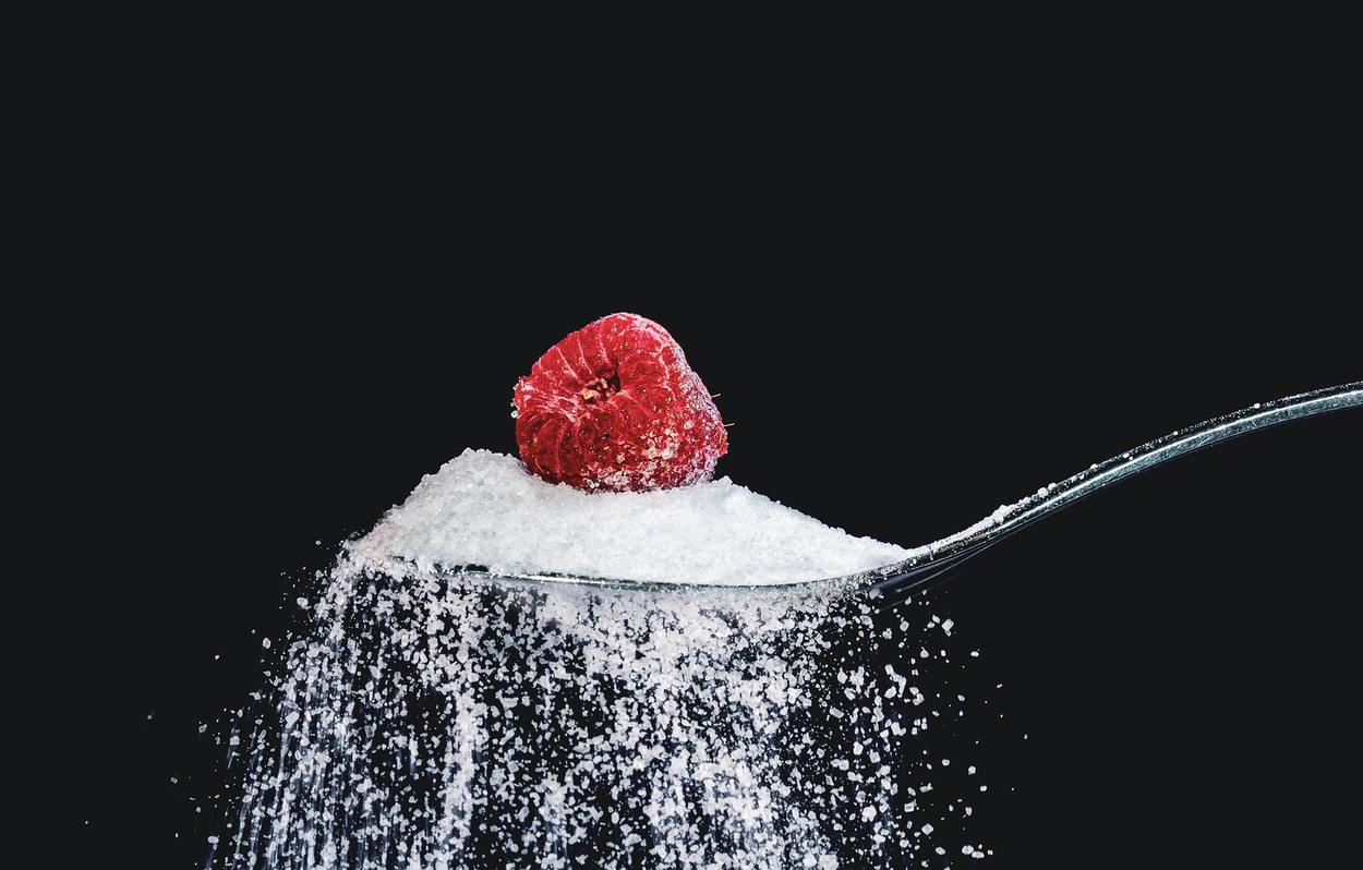 Image of sugar in spoon.