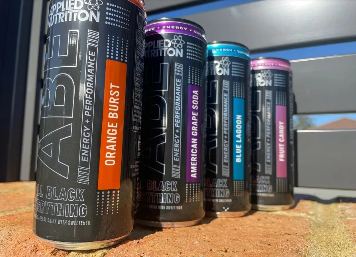 Four cans of energy drinks lined up on a wall