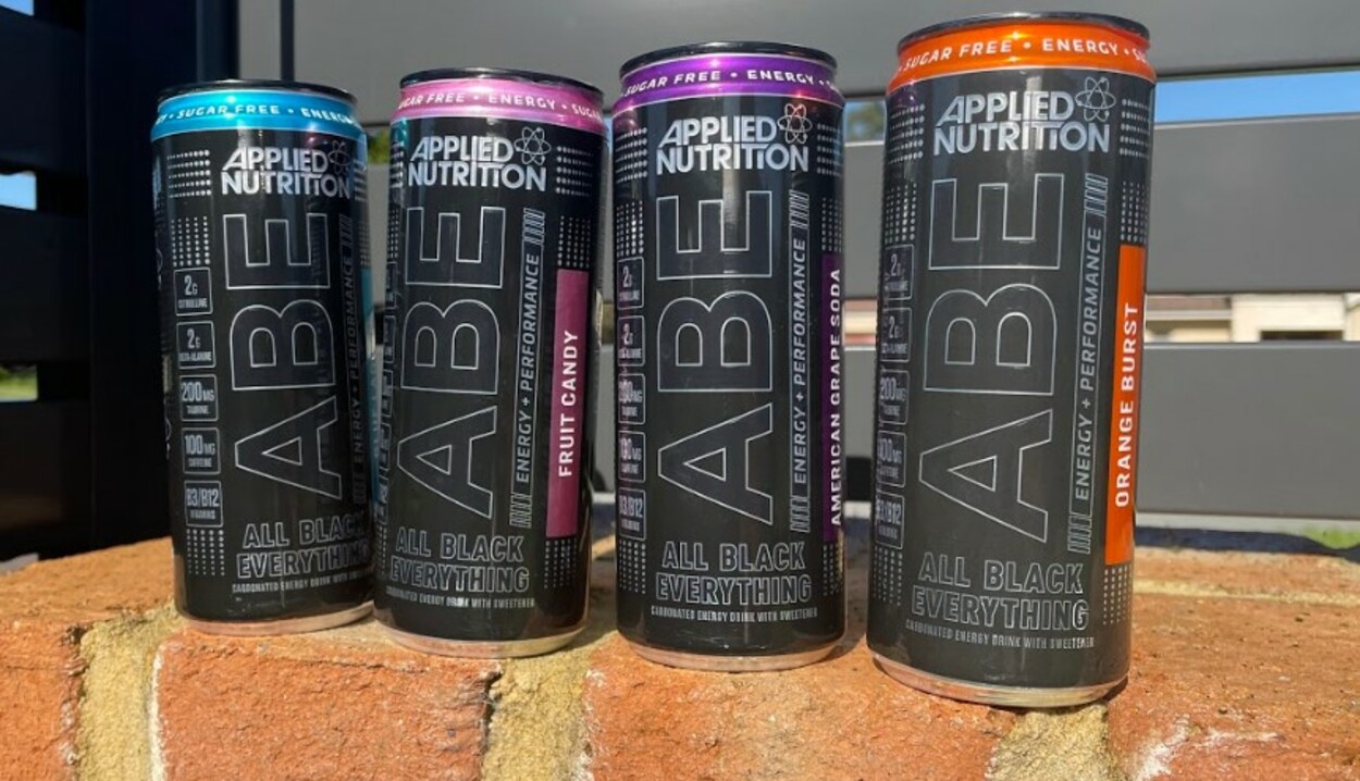 four cans of ABE energy drinks on a wall
