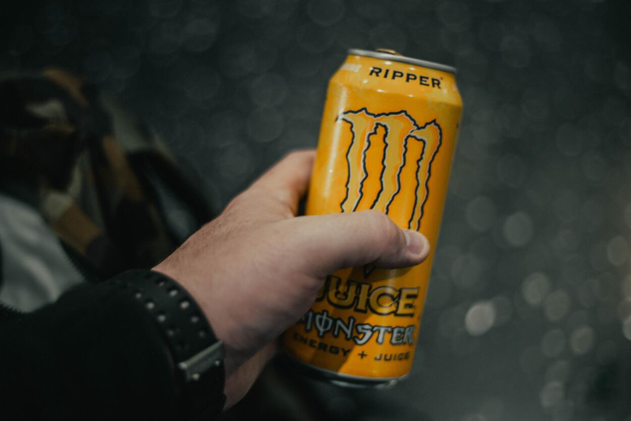 a person holding an energy drink